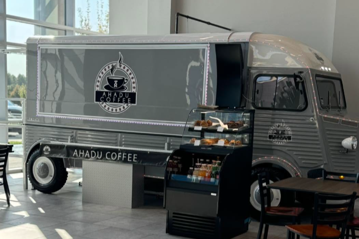 coffee truck inside of a lobby with a small refrigerated cooler
